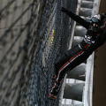 Noah Gragson climbs the fence after the win at Kansas Speedway
